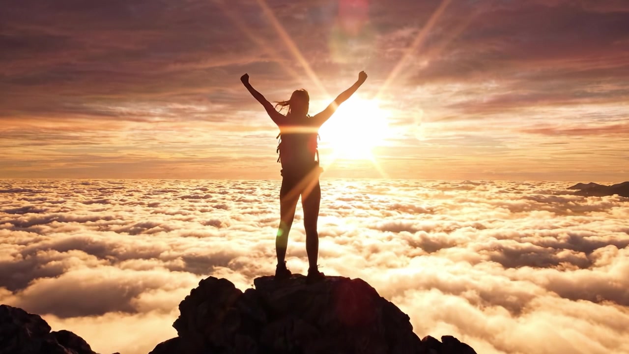 Un viaggio verso la vetta: celebrando lo spettacolare sorgere del sole sopra le nuvole con un senso di realizzazione e connessione alla bellezza della natura.