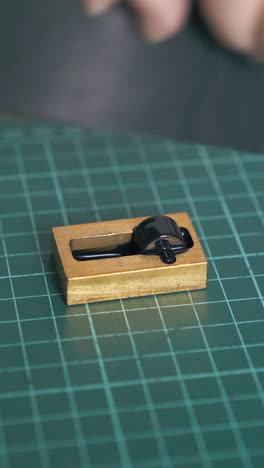 cu: woman colours leather strip edge into black with special pure copper on green cutting mat close view