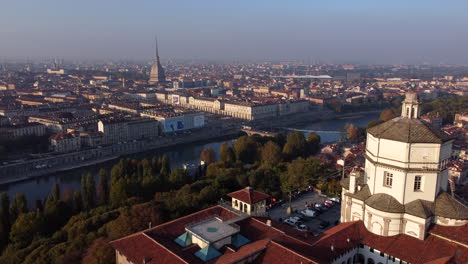 sunset aerial over turin, po river and the monte dei cappuccini, foggy day