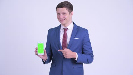 happy young handsome businessman with phone