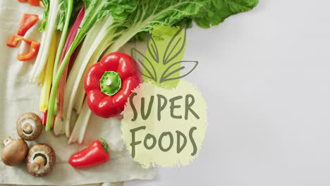 Super foods text animation over fresh vegetables including bell pepper and mushrooms