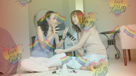 love is love text animation over two women sitting and using smartphones