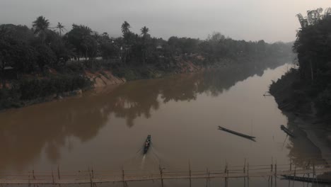 Boat-cruising-on-mekong-river-near-luang-prabang-during-sunrise,-aerial