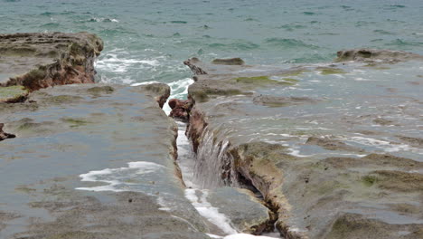 slowmotion shot of ocean water falling into a crevice created at punta bruja