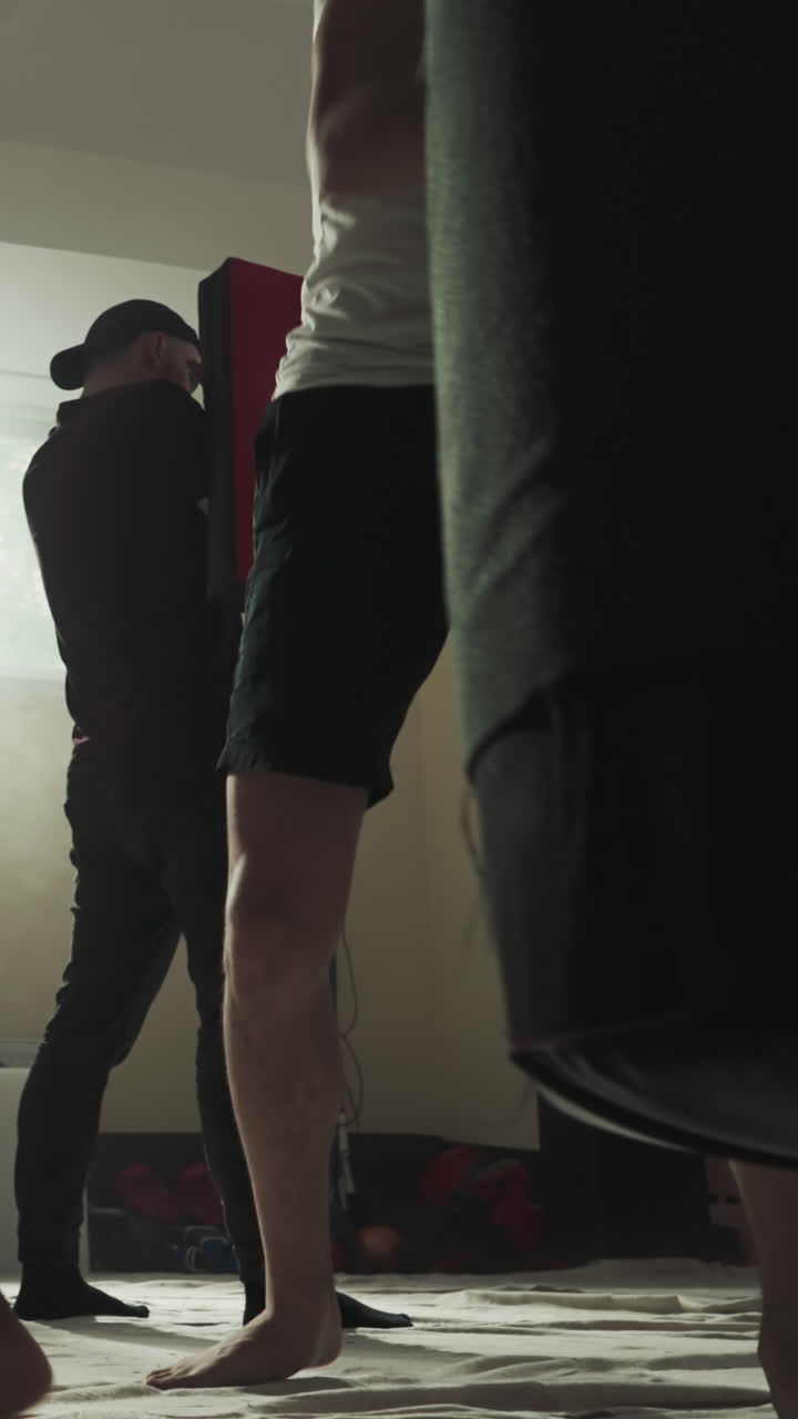 los boxeadores se ejercitan con equipos de golpeo en un club deportivo. los kickboxers descalzos entrenan al equipo para competir en el gimnasio de lucha en cámara lenta. los maestros de artes marciales