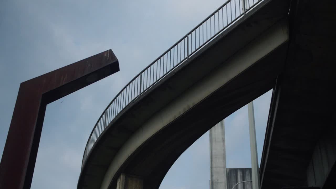 A close-up view underneath the Europabrug bridge in Vilvoorde, highlighting its bold curves and angular design