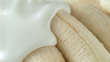 plátanos vertidos con yogur - un líquido espeso cubre la fruta en cámara lenta