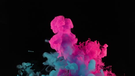 gotas de pintura de colores mezclándose en el agua. tinta girando bajo el agua. nube de pinturas sedosas aisladas sobre fondo negro