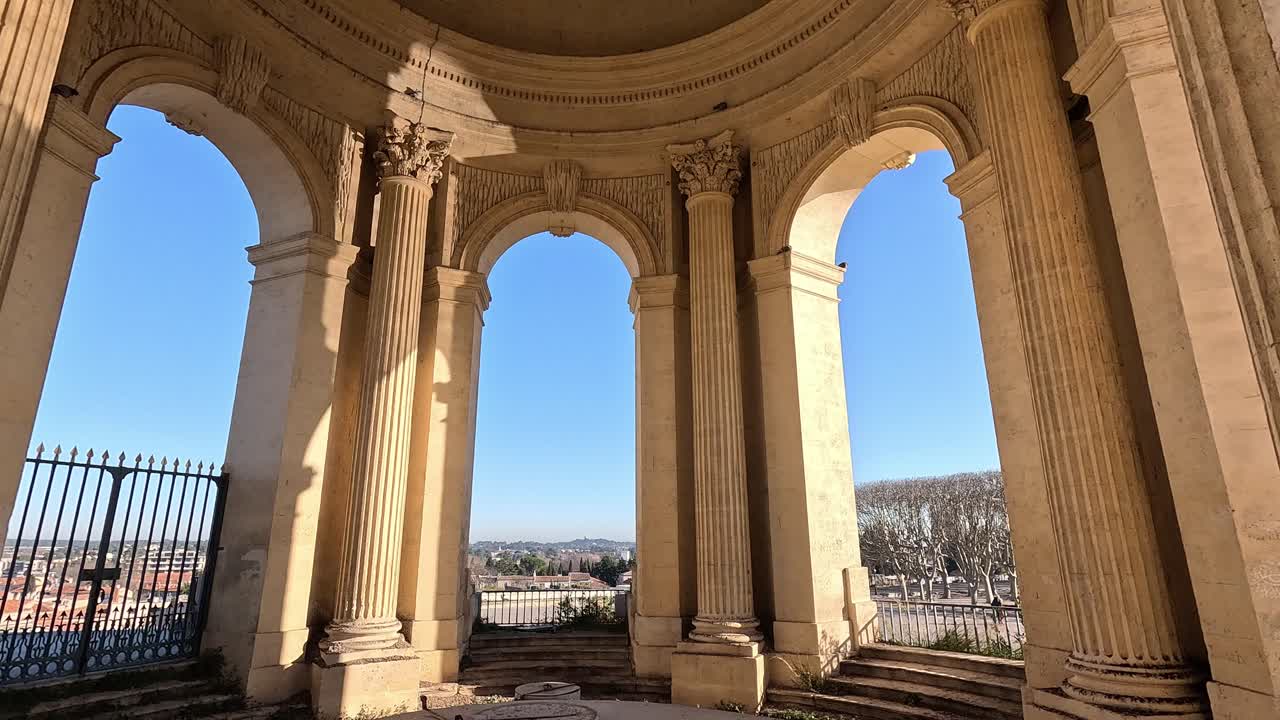 Inside the Château d'Eau monument in Montpellier France, with classical columns and city views under a clear blue sky