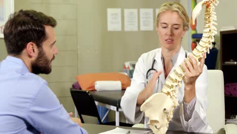 Physiotherapist-explaining-spine-model-to-patient