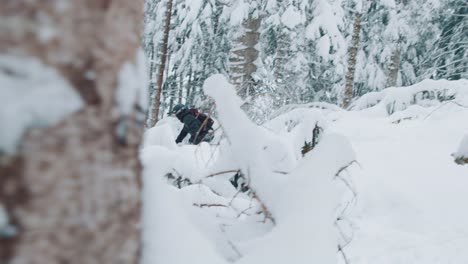 man doing a slow-motion jump on skis in deep powder snow in a tall pine forest