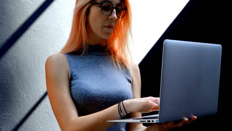 mujer con gafas usando computadora portátil 4k