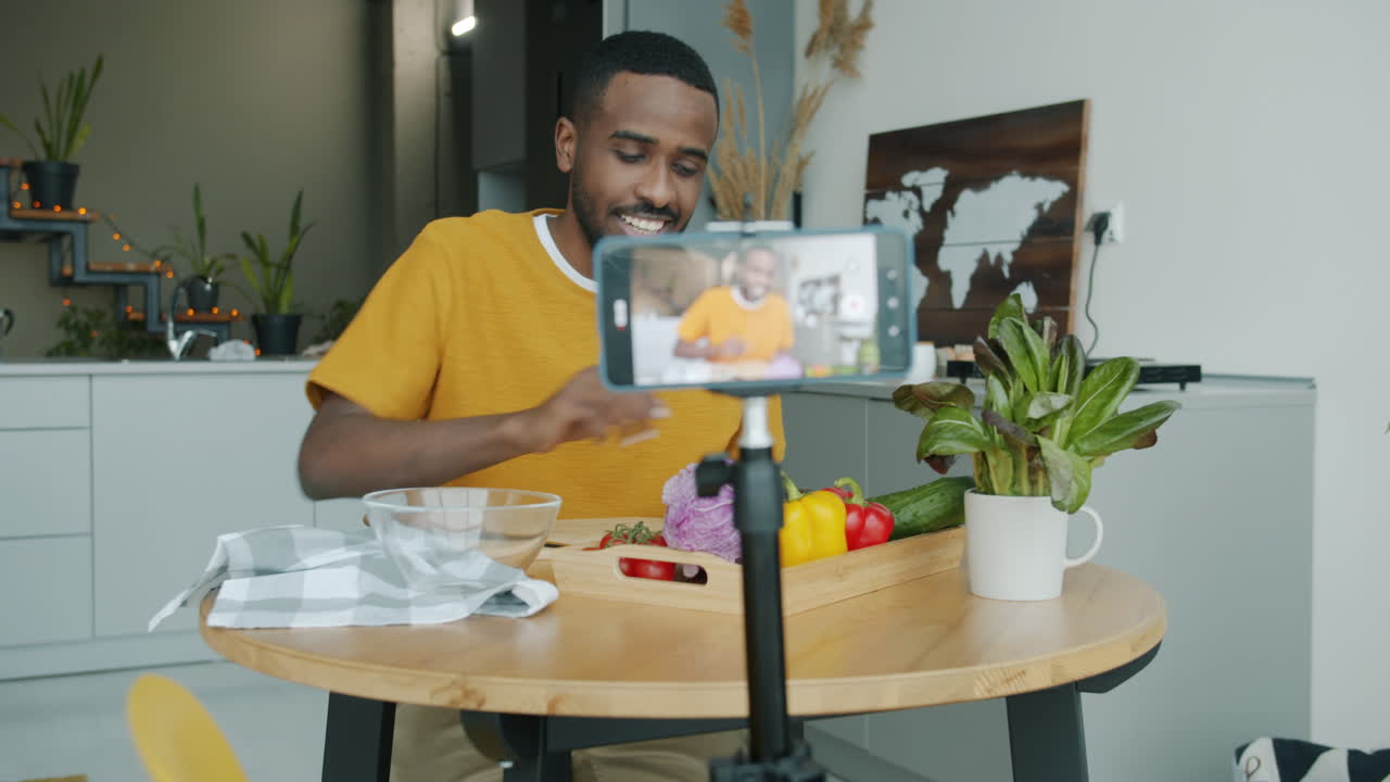 Uomo che cucina un pasto sano e lo condivide tramite video tutorial