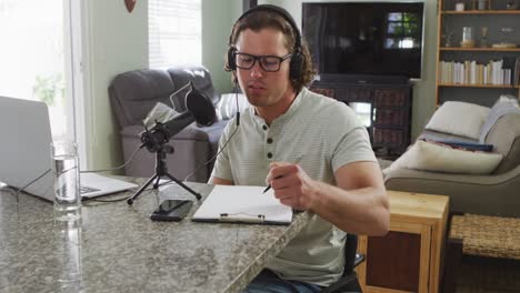 Focused-caucasian-man-working-remotely,-using-laptop-and-headphones