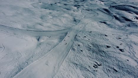 Menschen,-Die-Auf-Einer-Weißen-Skipiste-Bergab-Fahren,-Luftaufnahme