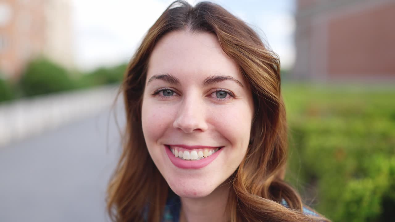 Close-up portrait of a smiling young woman outdoors