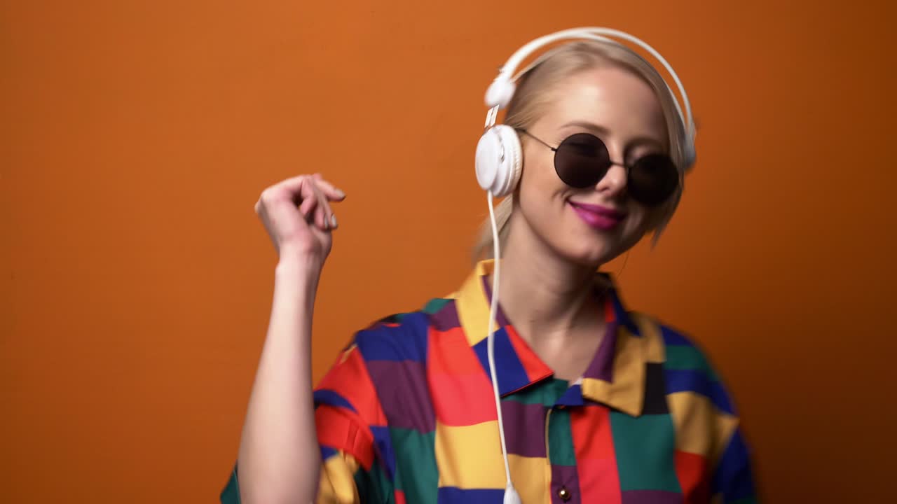 estilo rubia en camisa de los años 90 y auriculares está bailando
