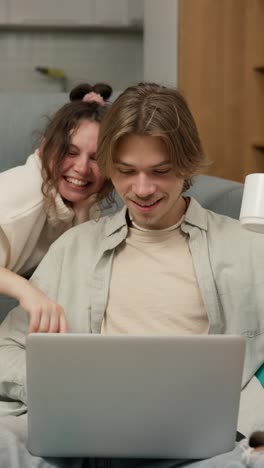 couple relaxing at home using laptop