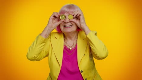 Senior-old-stylish-granny-woman-showing-golden-bitcoins,-cryptocurrency-investment-mining-technology