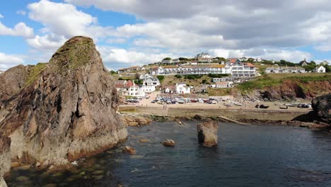 hope cove, inglaterra: una vista de un pueblo con una concurrida playa y una ciudad de vacacionistas