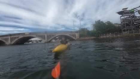 dynamic kayaking scene on river hamble, south england. features vibrant water, lush banks, dramatic clouds, bridge backdrop, and energetic activity. captured in vivid, natural light