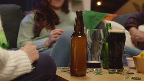 close-up von einer gruppe von freunden, die zu hause oder in einer bar auf dem sofa sitzen und den st. patrick's day mit einer party feiern und alkohol trinken 2