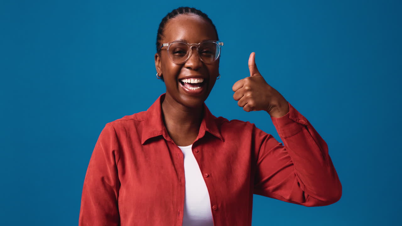 A woman expressing positive and negative emotions with thumbs up and thumbs down gestures