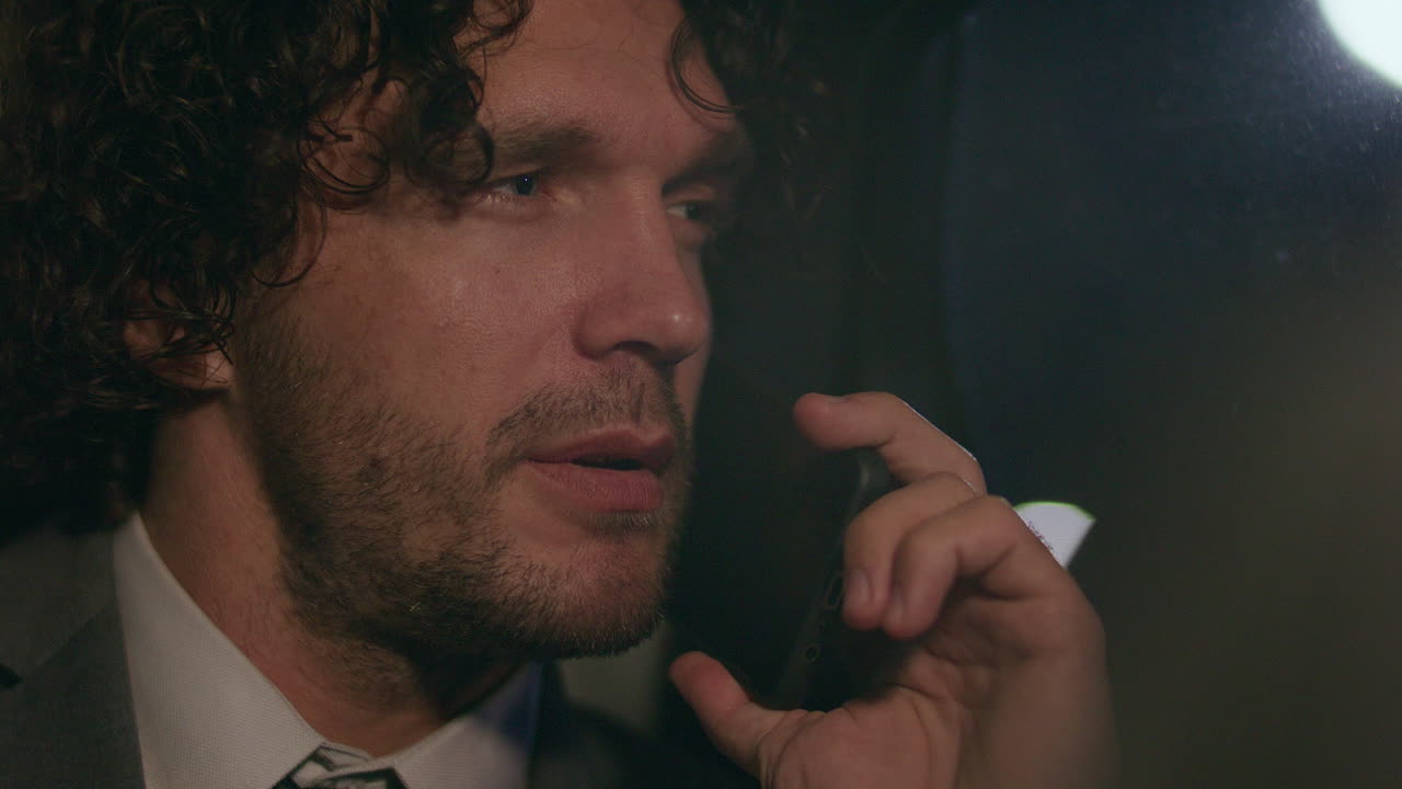 Young Businessman Talking on Cell Phone inside Car during Night Ride