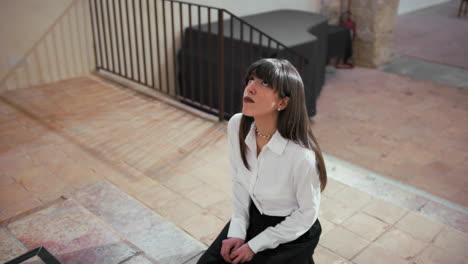 woman looking up in the church while praying on her knees