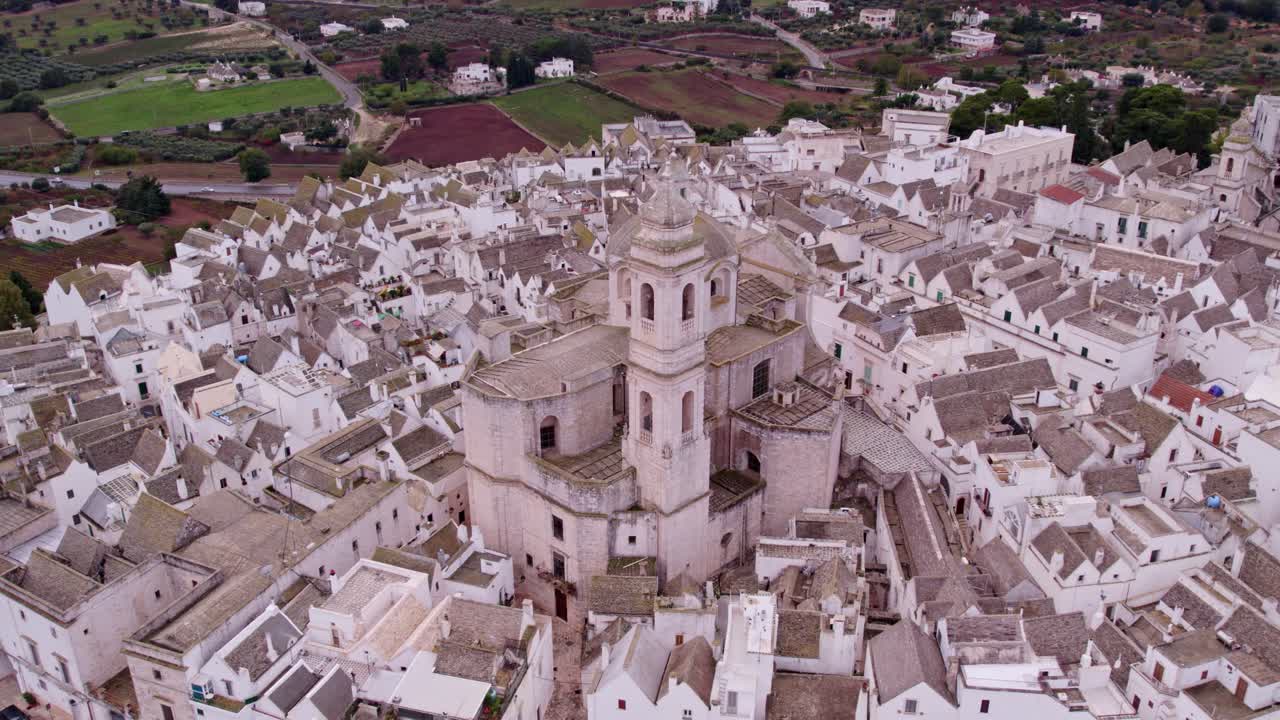 Iconica città imbiancata a calce sotto un cielo nuvoloso e drammatico