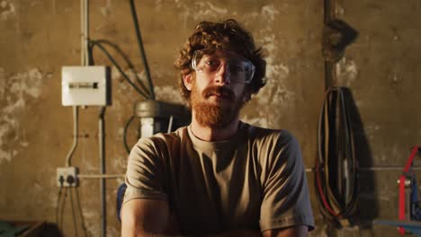retrato de un herrero caucásico con gafas de seguridad en el taller
