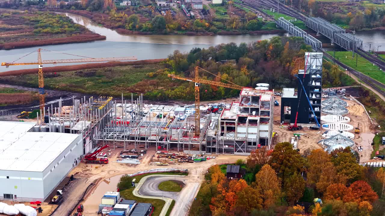 Aerial view of a construction site by a river in autumn colors