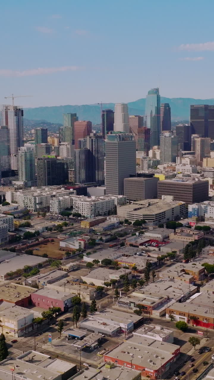 High buildings of amazing financial district in Los Angeles, USA. Hazy hills of California at backdrop. Aerial view. Vertical video