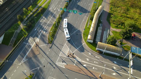 daytime scene at the road near the railways in gdynia, poland with trams and cars travelling - high angle shot