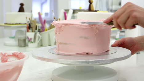 Nahaufnahme-Einer-Frau-In-Einer-Bäckerei,-Die-Kuchen-Mit-Zuckerguss-Dekoriert