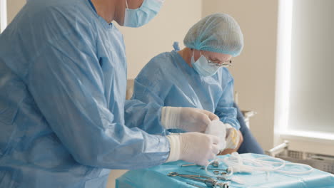 surgeons preparing medical equipment in operating room