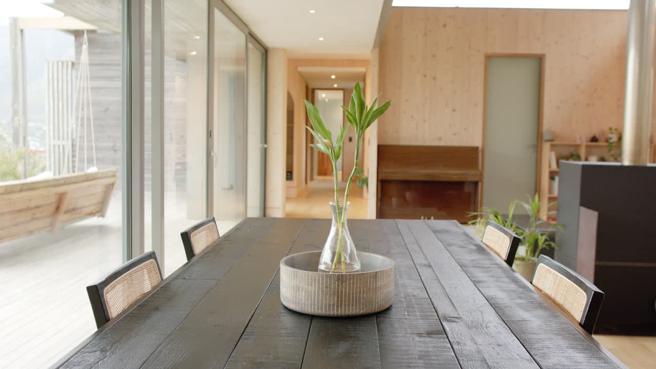 Modern dining room with wooden table and vase, bright and inviting atmosphere, copy space
