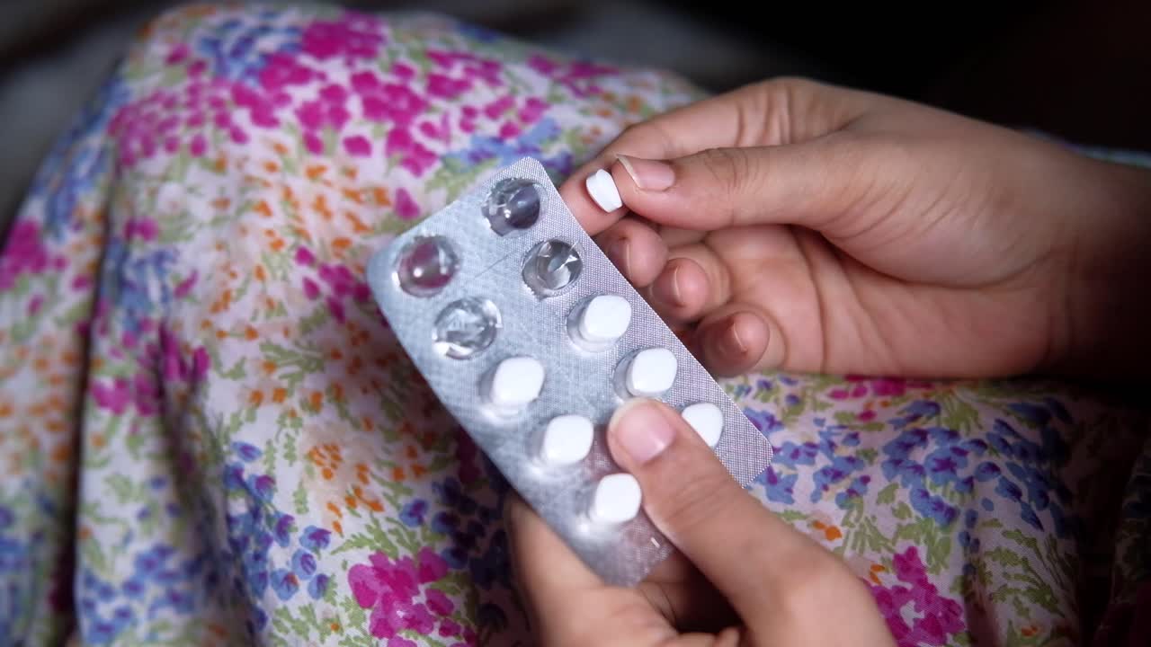 mujer sosteniendo un paquete de pastillas