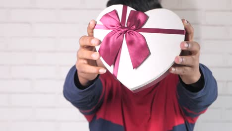 person holding a heart shaped gift box