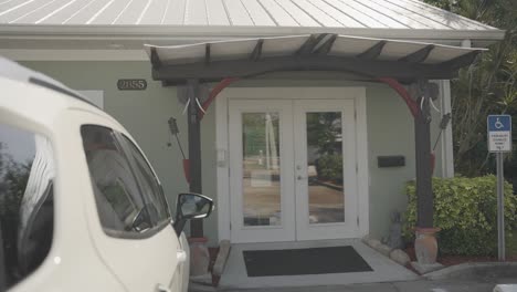 stunning sight of a residence's entrance featuring a ramp for disabled access above a parked vehicle.