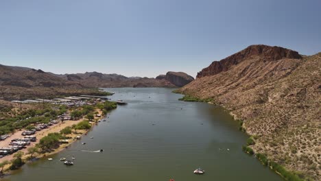 Canyon-Lake-in-Tortilla-Flat-Az-near-Phoenix-rising-aerial-drone-view-of-the-water,-mountains,-boats,-and-clear-blue-sky