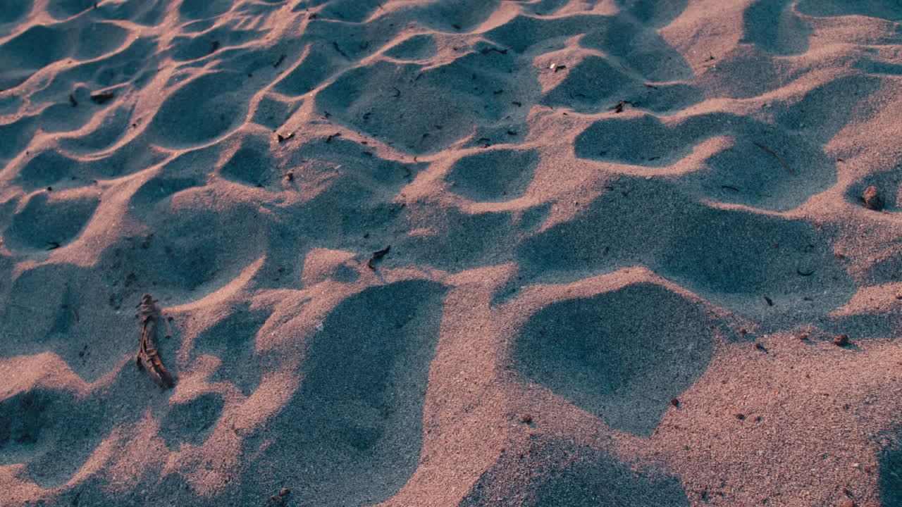 Close up a sand beach in Lofoten islands, Norway and the sunset shines bright on the sand giving some beautiful colors on a warm summer day