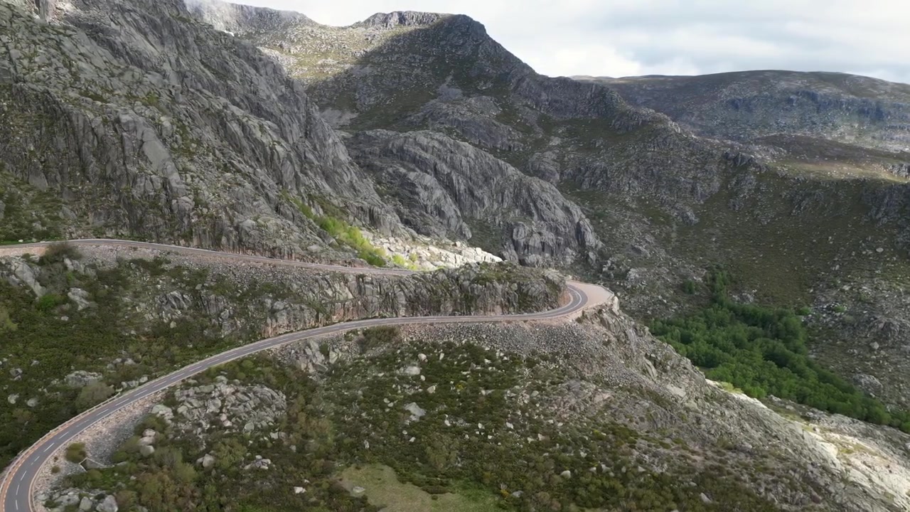 Luftoptagelser med drone af Serra da Estrela, Portugal: klippefyldte bjergtoppe, vandreservoirer og et stort naturlandskab under klart lys. Ideel til rejse- og naturprojekter