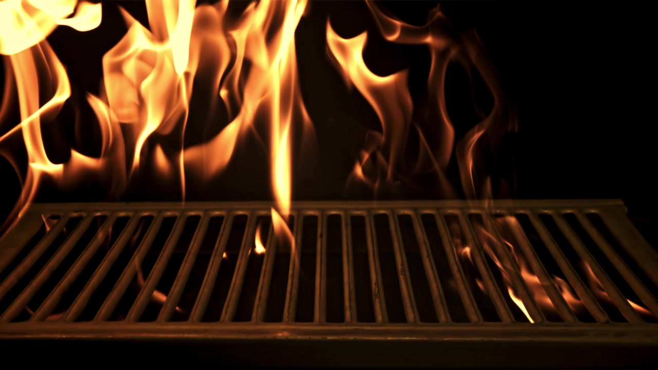 Griglia rovente con fiamme ardenti su sfondo nero