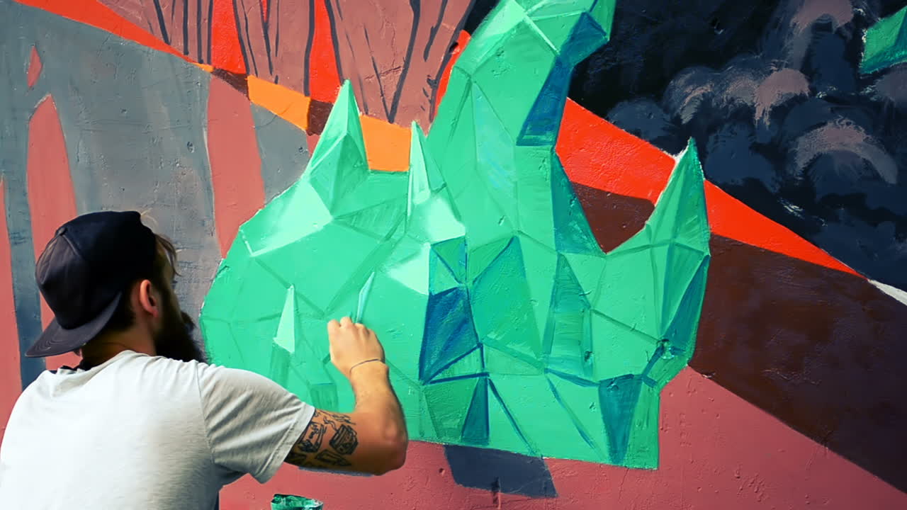 L'artista realizza graffiti su una recinzione. Disegno astratto