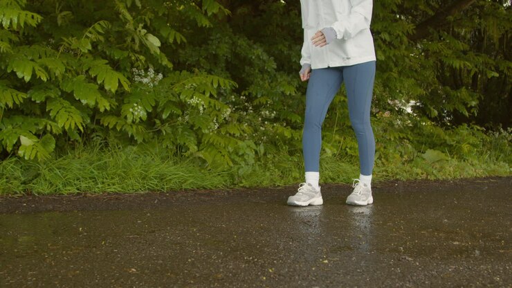 Close Up Of Woman Legs As She Exercises Keeping Fit Running In Rain