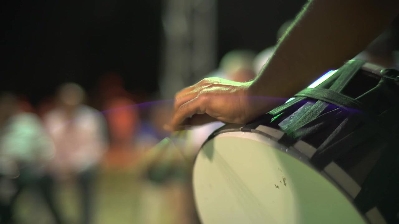 Musician Playing Traditional Drum at Nighttime Event