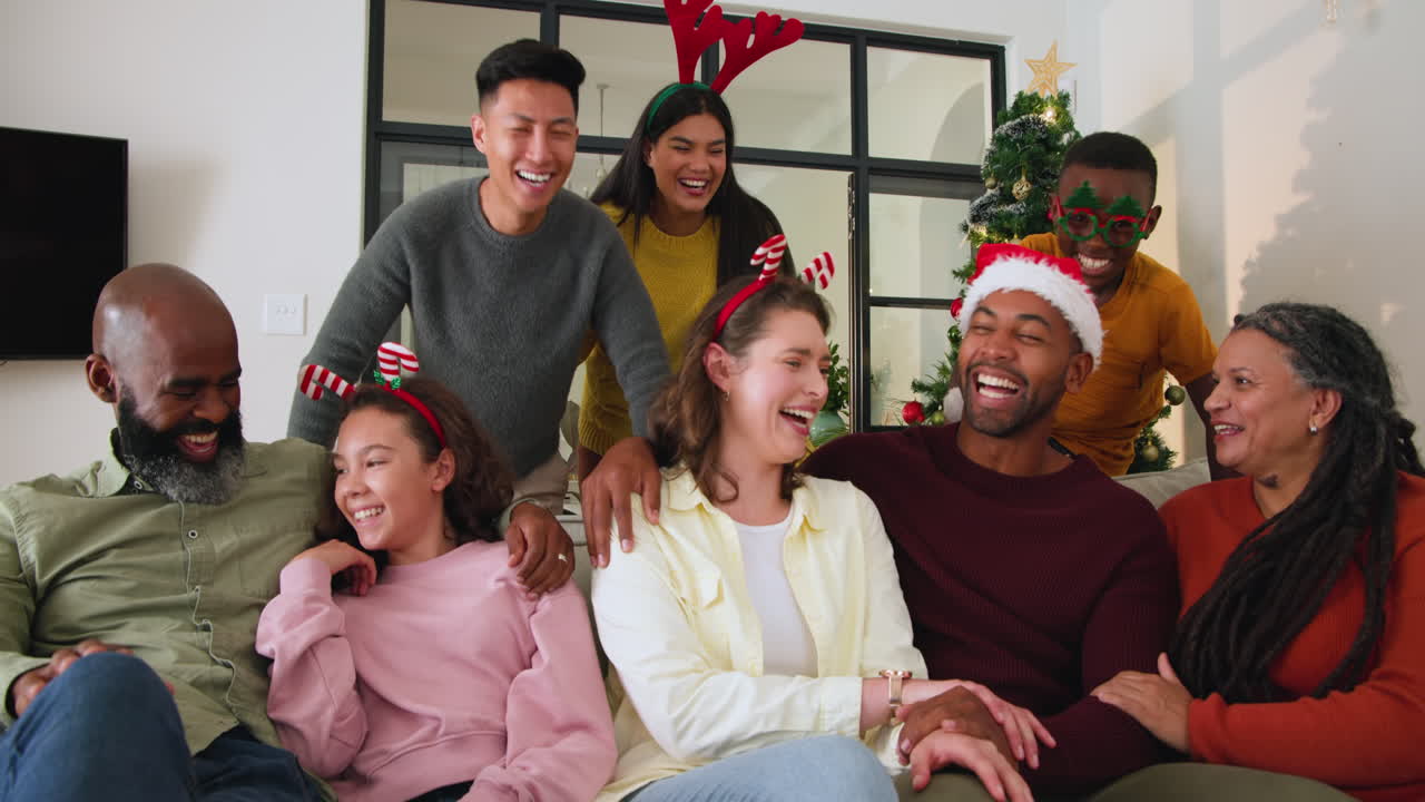 Diverse family celebrating Christmas at home, laughing together by tree