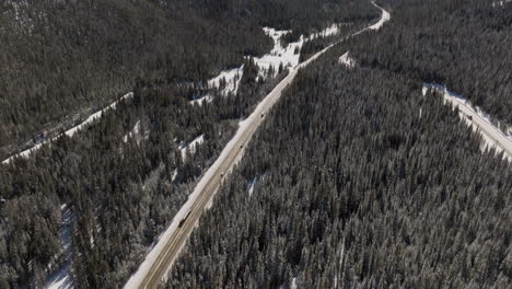 Aerial-tilting-shot-of-cars-driving-near-winter-park-in-colorado