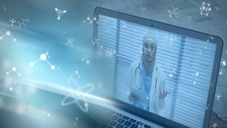 moléculas moviéndose sobre la doctora en la pantalla del portátil.